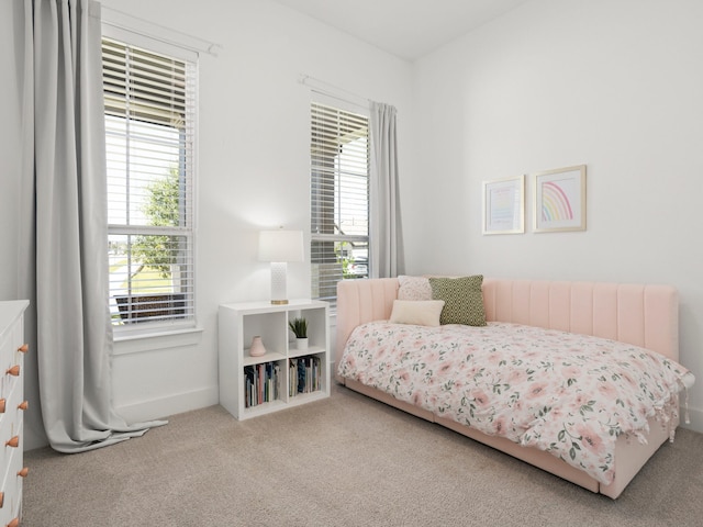 bedroom featuring light carpet and radiator