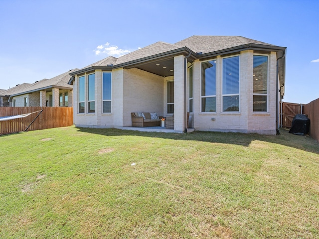 back of house with an outdoor living space and a yard