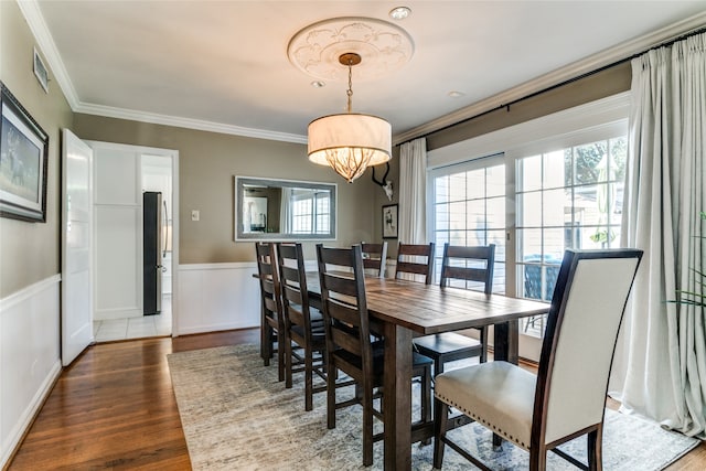 dining space with a notable chandelier, crown molding, and dark hardwood / wood-style flooring