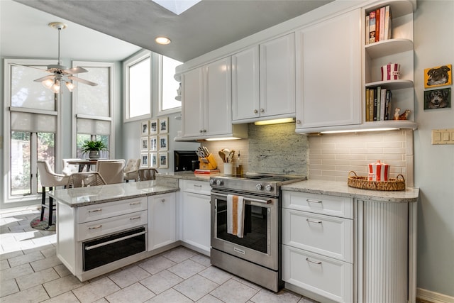 kitchen featuring kitchen peninsula, white cabinetry, stainless steel electric range oven, and plenty of natural light