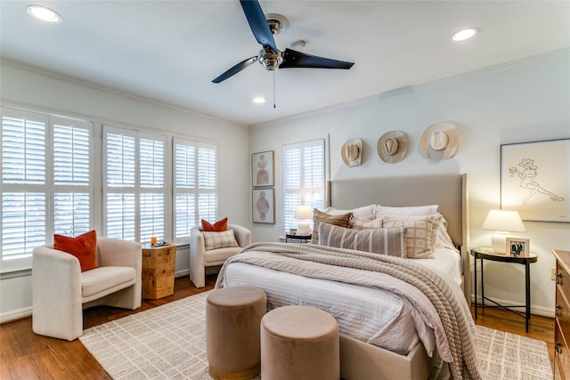 bedroom with ornamental molding, hardwood / wood-style floors, multiple windows, and ceiling fan