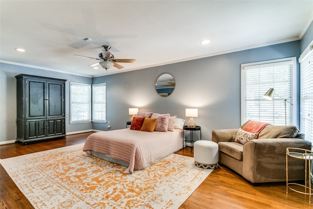 bedroom featuring ceiling fan, hardwood / wood-style flooring, and crown molding