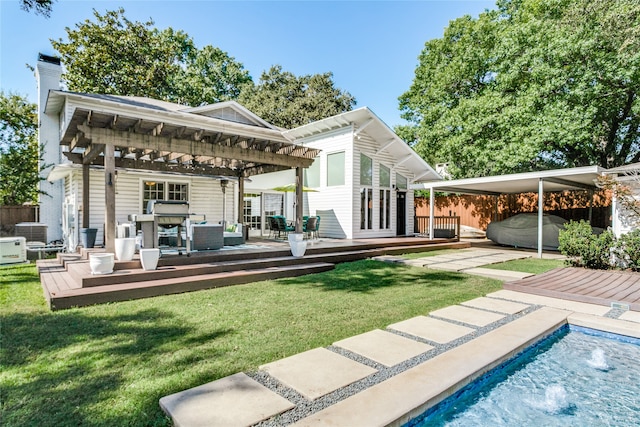 rear view of house with a lawn, a gazebo, and a swimming pool side deck