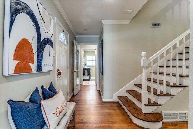 entryway with hardwood / wood-style flooring and crown molding