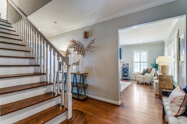 stairs with ornamental molding and hardwood / wood-style floors