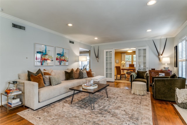 living room with wood-type flooring and crown molding