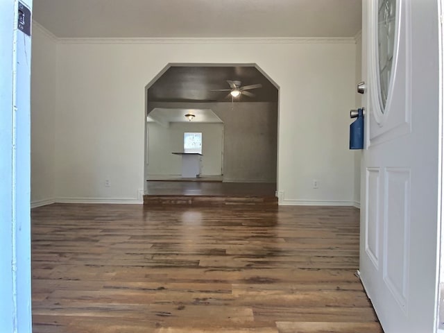 unfurnished living room featuring ceiling fan, ornamental molding, and dark hardwood / wood-style flooring