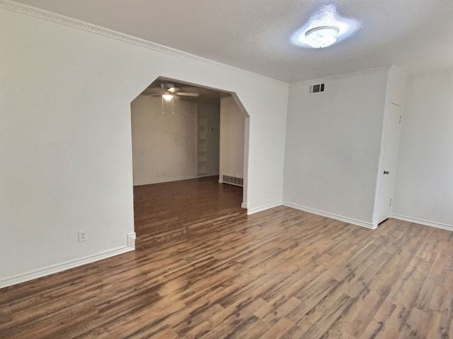 empty room with a textured ceiling, crown molding, hardwood / wood-style floors, and ceiling fan