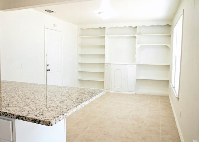 kitchen featuring light hardwood / wood-style flooring, white cabinets, dark stone countertops, and a center island