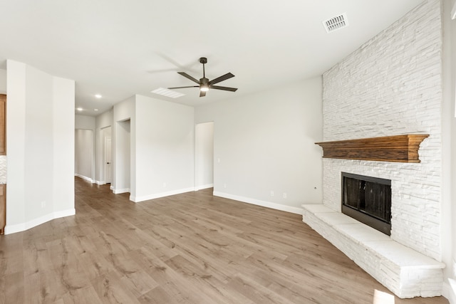 unfurnished living room with ceiling fan, light hardwood / wood-style floors, and a fireplace