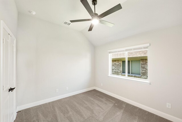 empty room featuring ceiling fan, light colored carpet, and vaulted ceiling