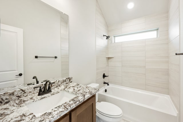 full bathroom with vanity, tiled shower / bath combo, vaulted ceiling, and toilet