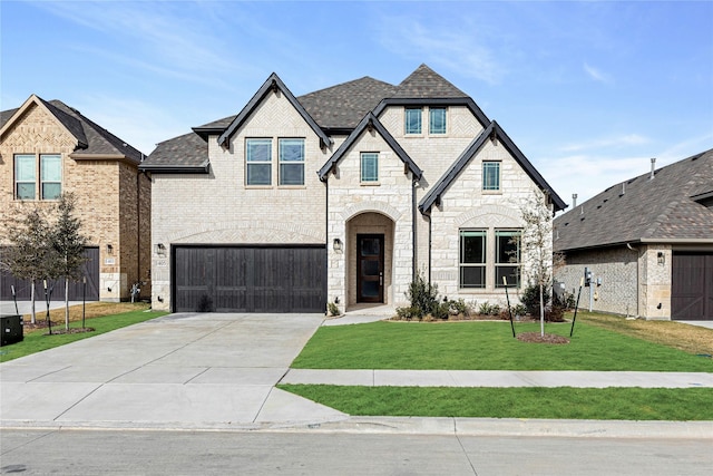 french country home with a garage and a front lawn