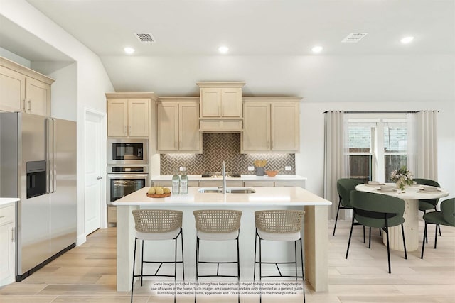 kitchen featuring sink, stainless steel appliances, and an island with sink