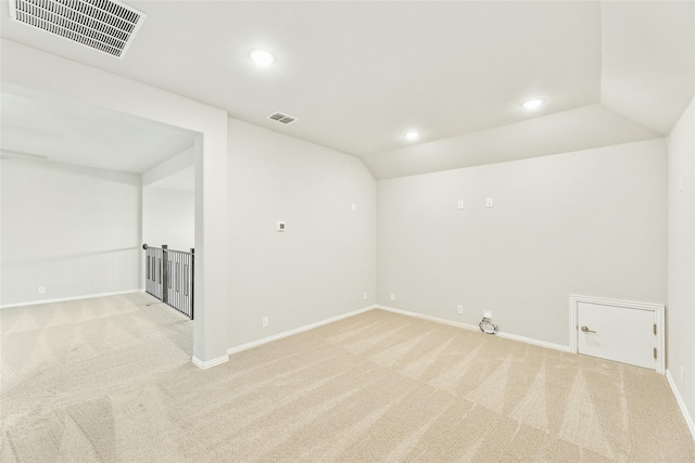 carpeted spare room with lofted ceiling