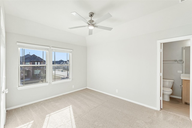 unfurnished bedroom with connected bathroom, light carpet, and ceiling fan