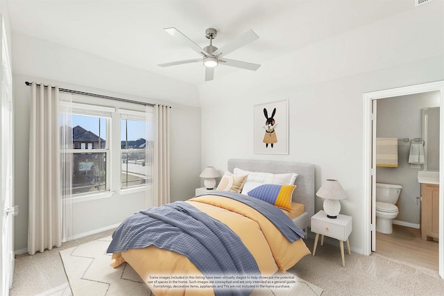 bedroom featuring ensuite bathroom, ceiling fan, and light colored carpet