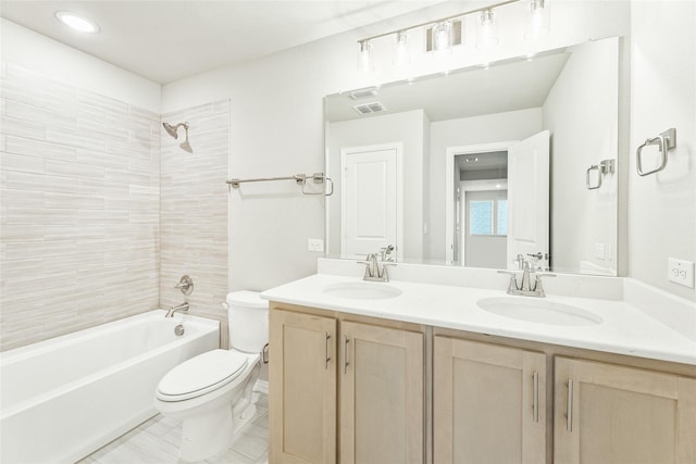 full bathroom with tiled shower / bath, vanity, and toilet