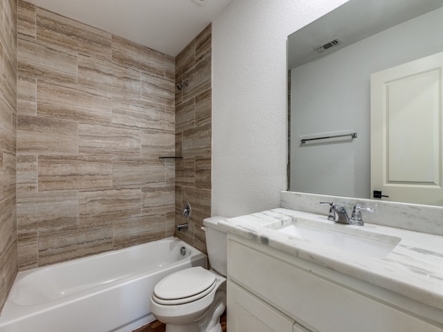 full bathroom with tiled shower / bath combo, toilet, and vanity