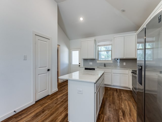 kitchen with white cabinets, stainless steel appliances, vaulted ceiling, and a kitchen island