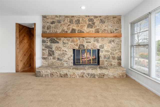 unfurnished living room with carpet floors, a healthy amount of sunlight, and a fireplace