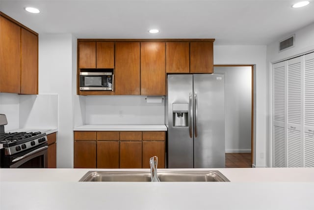 kitchen with stainless steel appliances, tile patterned flooring, and sink