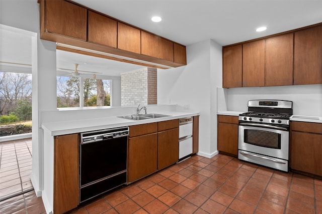 kitchen with dishwasher, ceiling fan, stainless steel range with gas stovetop, dark tile patterned floors, and sink