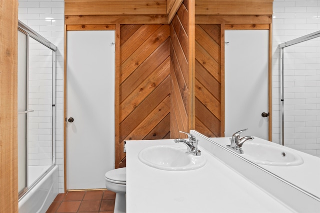 full bathroom featuring bath / shower combo with glass door, vanity, tile patterned flooring, and toilet