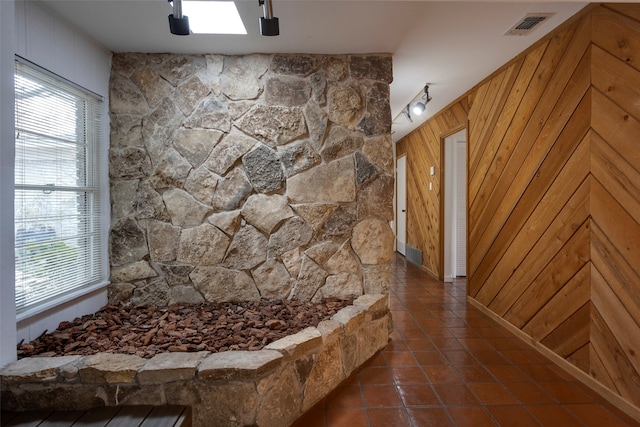 interior space with tile patterned flooring and wood walls