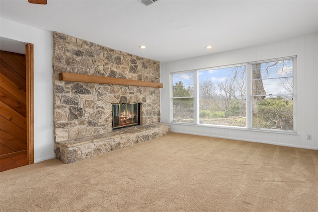 unfurnished living room featuring carpet flooring and a stone fireplace