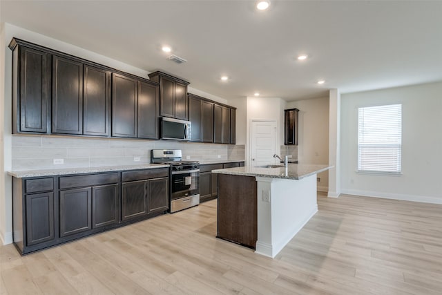 3725 Blooming Prairie Dr, Crandall, TX 75114 - kitchen with decorative backsplash, visible vents, appliances with stainless steel finishes, a sink, and light stone counters