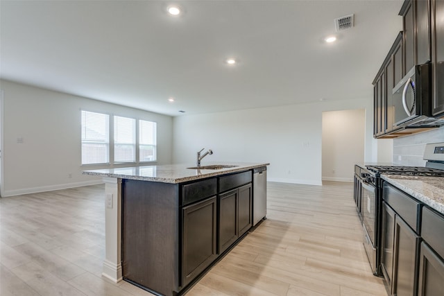 3725 Blooming Prairie Dr, Crandall, TX 75114 - kitchen featuring visible vents, light wood-style flooring, appliances with stainless steel finishes, a sink, and an island with sink