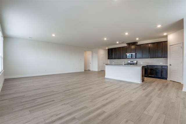 3725 Blooming Prairie Dr, Crandall, TX 75114 - kitchen with backsplash, open floor plan, stainless steel appliances, and light wood-style floors