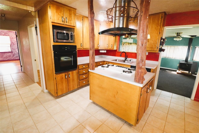 kitchen with a kitchen island, island exhaust hood, oven, hanging light fixtures, and sink