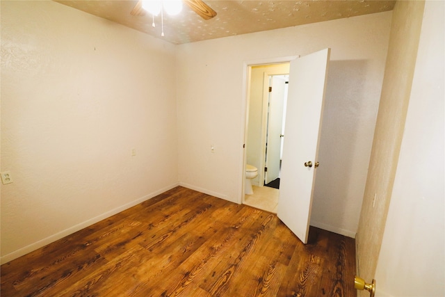 spare room with dark wood-type flooring and ceiling fan