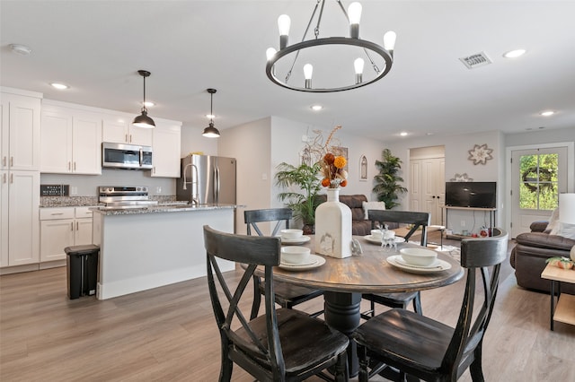 dining room featuring light hardwood / wood-style flooring and a notable chandelier