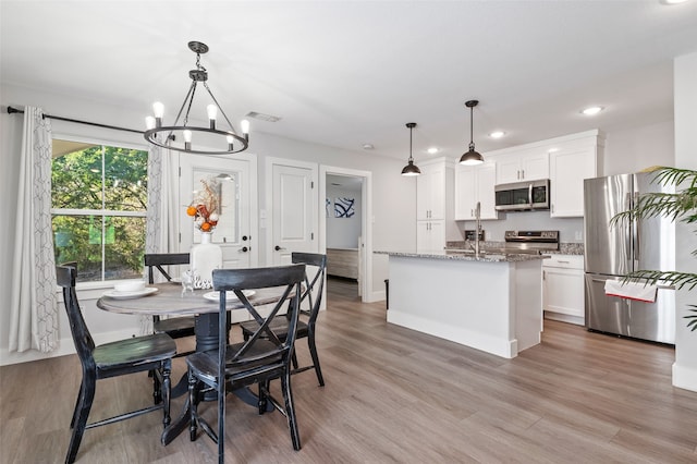 dining area featuring a notable chandelier and hardwood / wood-style flooring