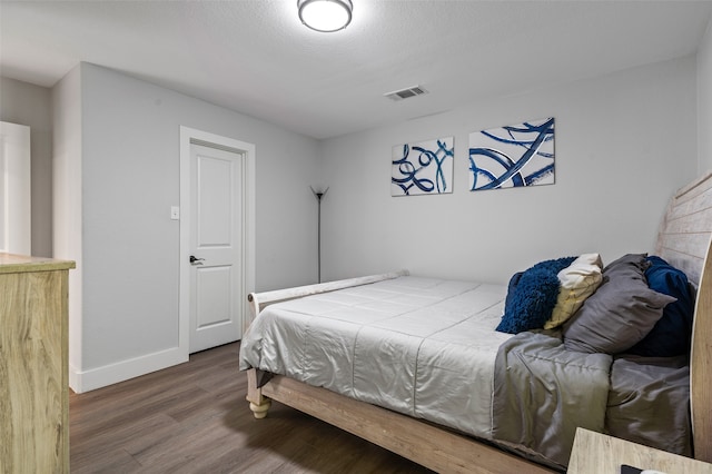 bedroom with wood-type flooring and a textured ceiling