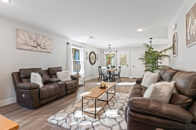 living room featuring a notable chandelier and hardwood / wood-style flooring