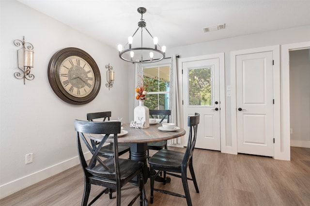 dining room featuring an inviting chandelier and light hardwood / wood-style flooring