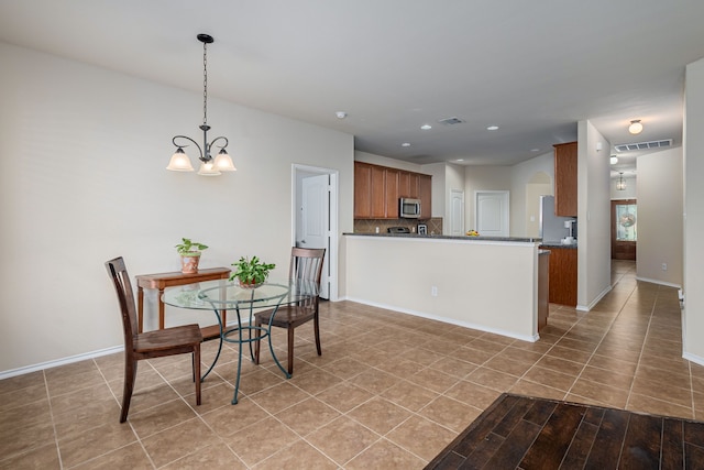 dining room featuring tile patterned flooring and a notable chandelier