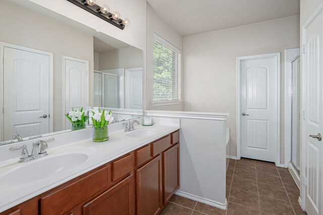 bathroom featuring tile patterned floors, a shower with door, and vanity