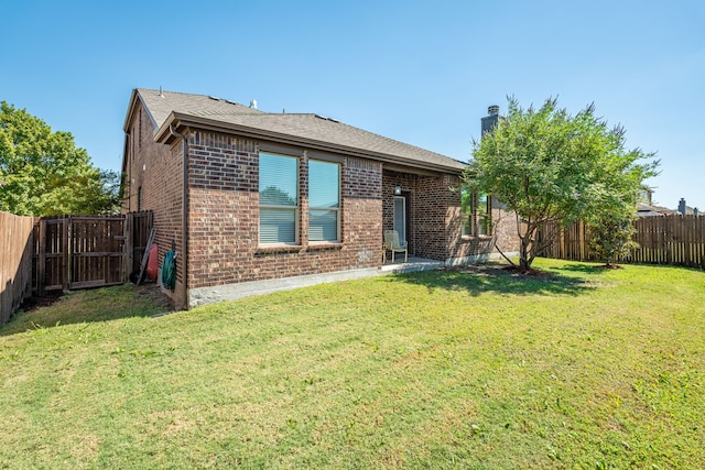 rear view of house featuring a yard