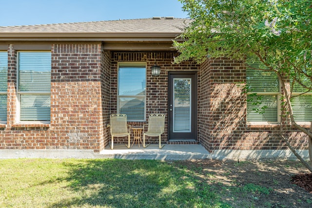 doorway to property featuring a lawn and a patio