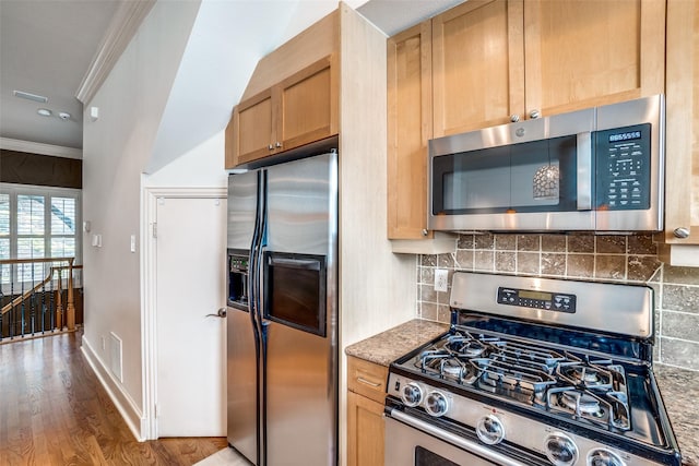 kitchen with ornamental molding, wood finished floors, stainless steel appliances, light brown cabinets, and backsplash