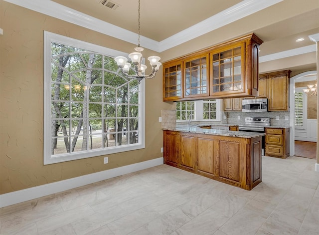 kitchen with brown cabinets, an inviting chandelier, light stone countertops, and stainless steel appliances