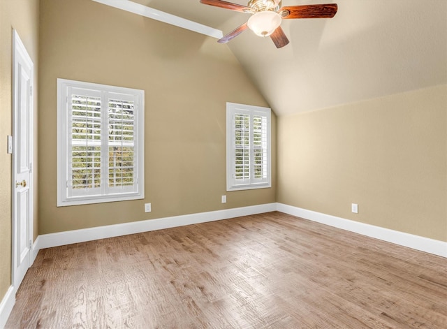 interior space with wood finished floors, ceiling fan, baseboards, and lofted ceiling