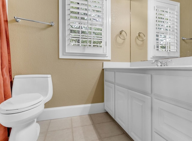 bathroom with vanity, tile patterned flooring, toilet, a textured wall, and baseboards