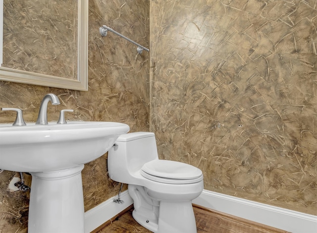 bathroom featuring wood-type flooring and toilet