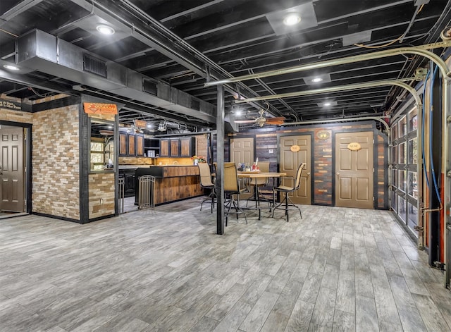 unfurnished dining area with brick wall and hardwood / wood-style flooring